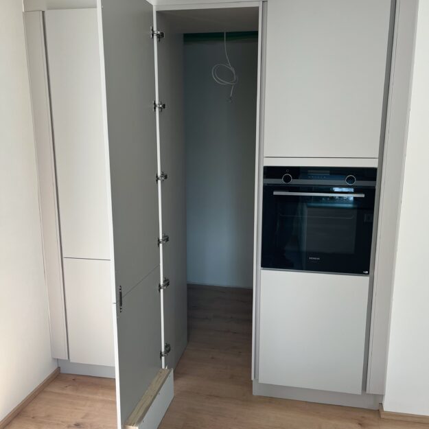 Moderne weiße Hochschränke mit Durchgang zum Haushaltsraum