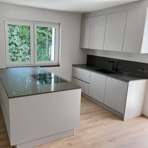 moderne weiße Küche mit schwarzer Arbeitsfläche